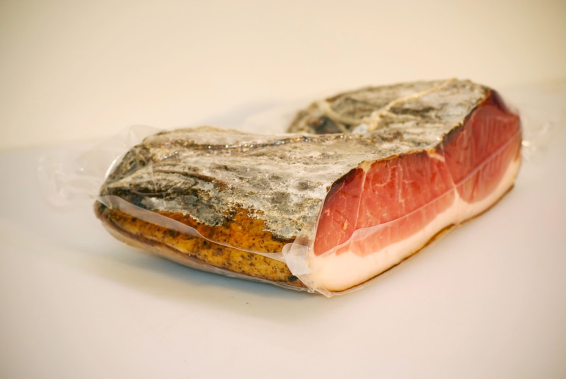 A slab of prosciutto on white background