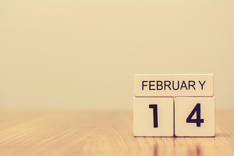 February 14 date on wooden label calendar place on table