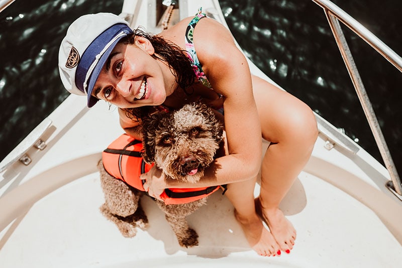 Playing with her lovely brown spanish water dog on the yatch