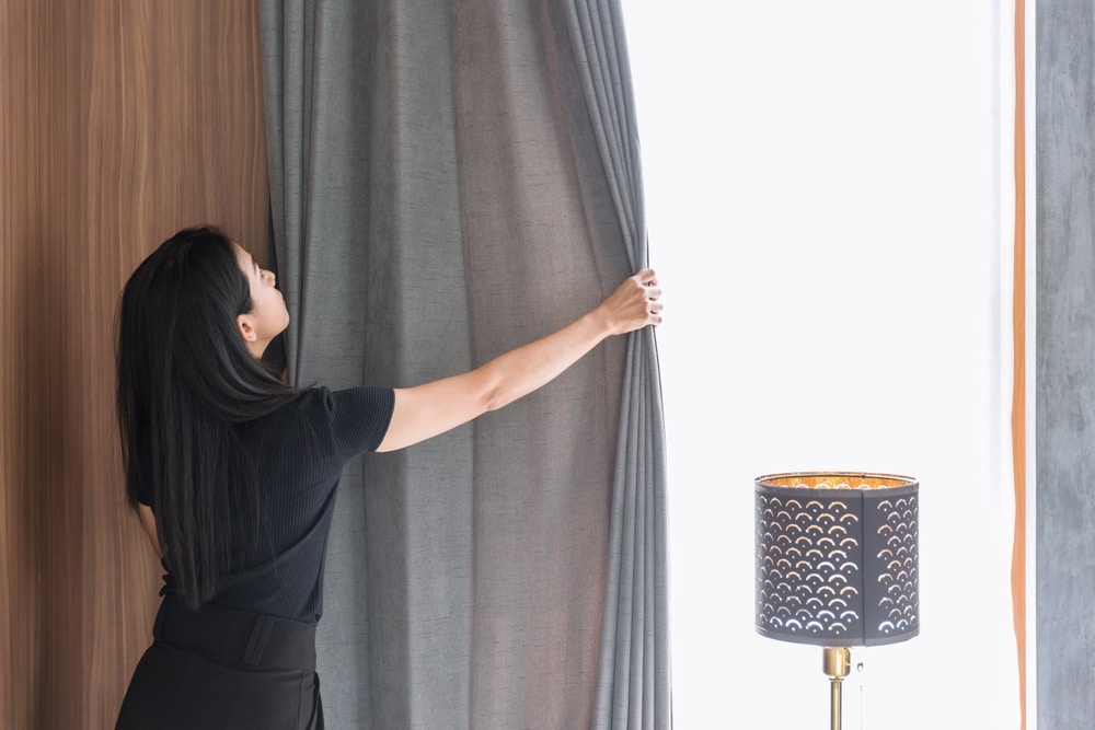 Woman closing curtains