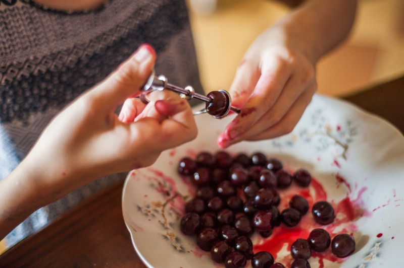 Woman removing pit from cherries