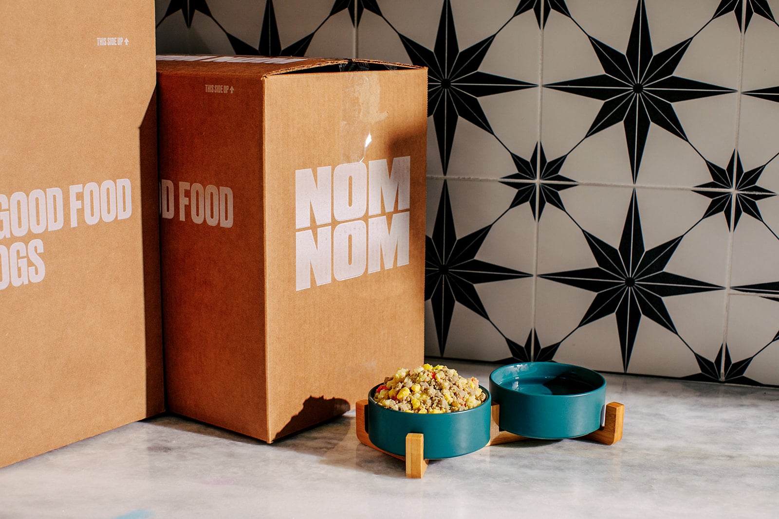 a nom nom dog food in a bowl in front of its box