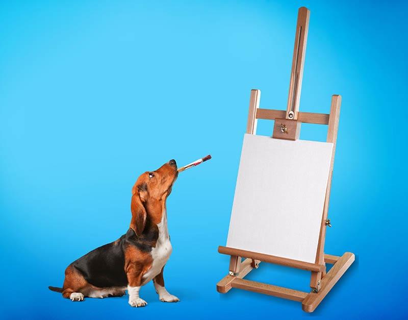 beagle dog holding a paint brush in its mouth and an easel on the side