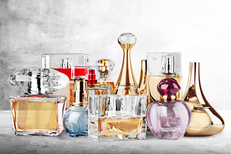 collection of colored glass perfume bottles on the desk