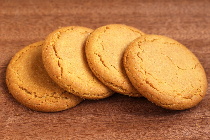 four ginger biscuits on a dark wooden background