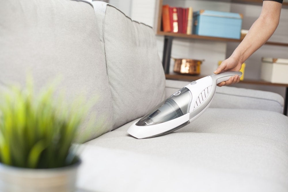 cleaning couch with a handheld vacuum