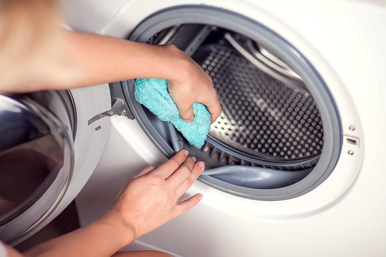 person wiping washing machine