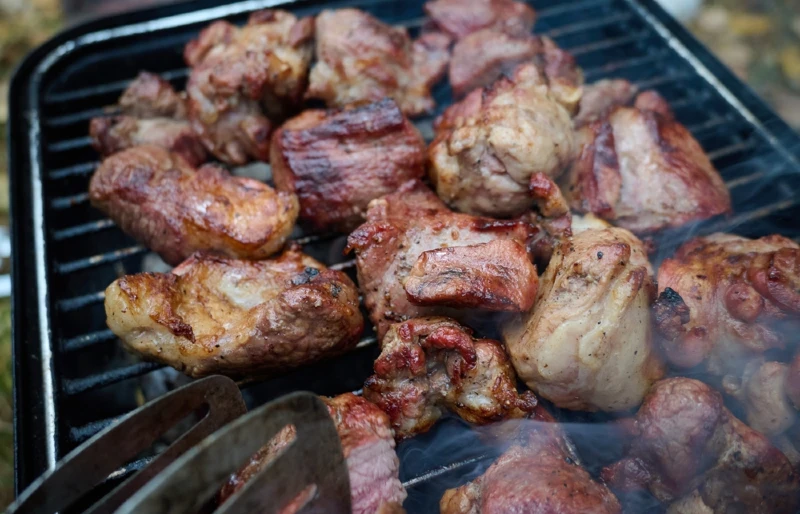 roasted peaces of goat meat cooked on a BBQ grill