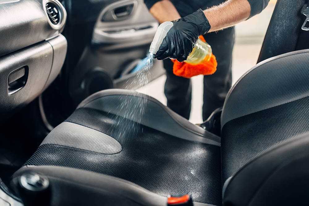spraying car seat with water