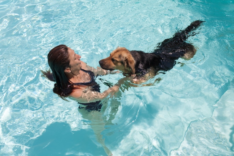 woman swimming with her dog