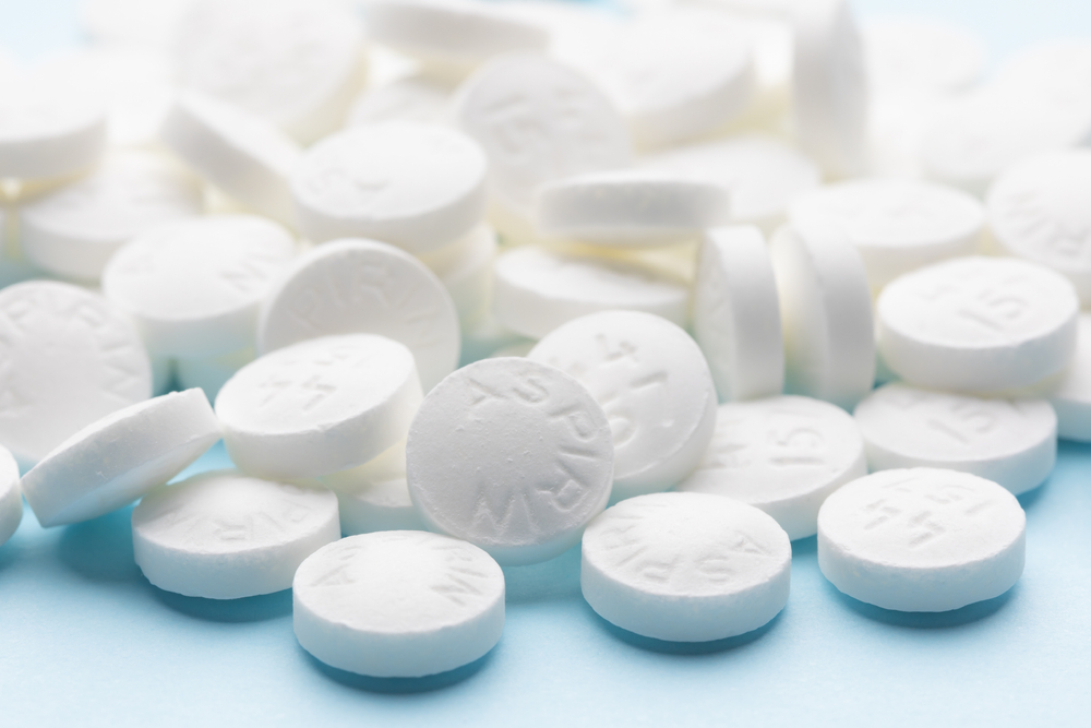 White aspirin pills on blue table